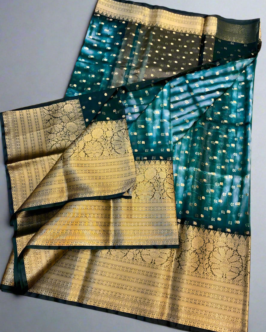 Traditional saree with green and gold patterns on a gray background