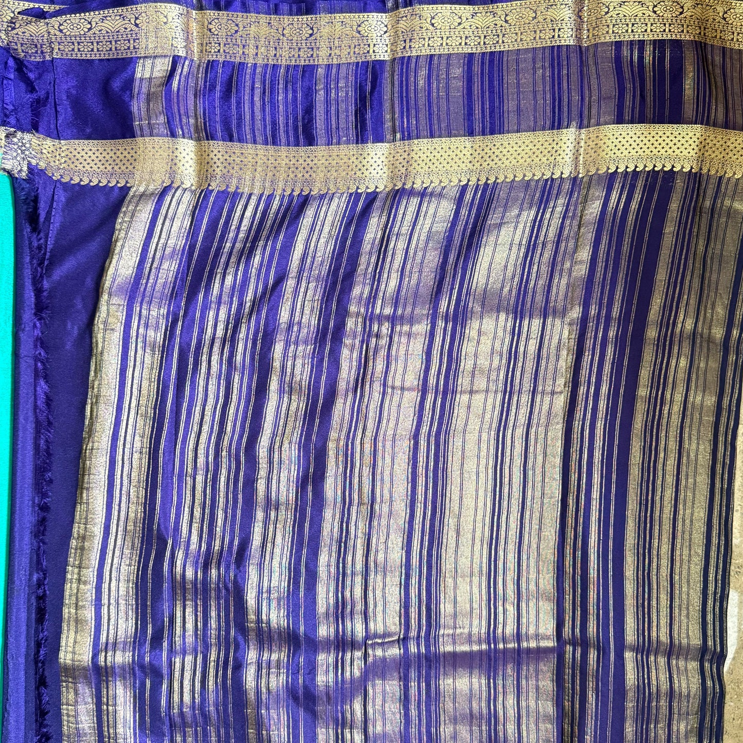 Blue and gold striped fabric on a plain background