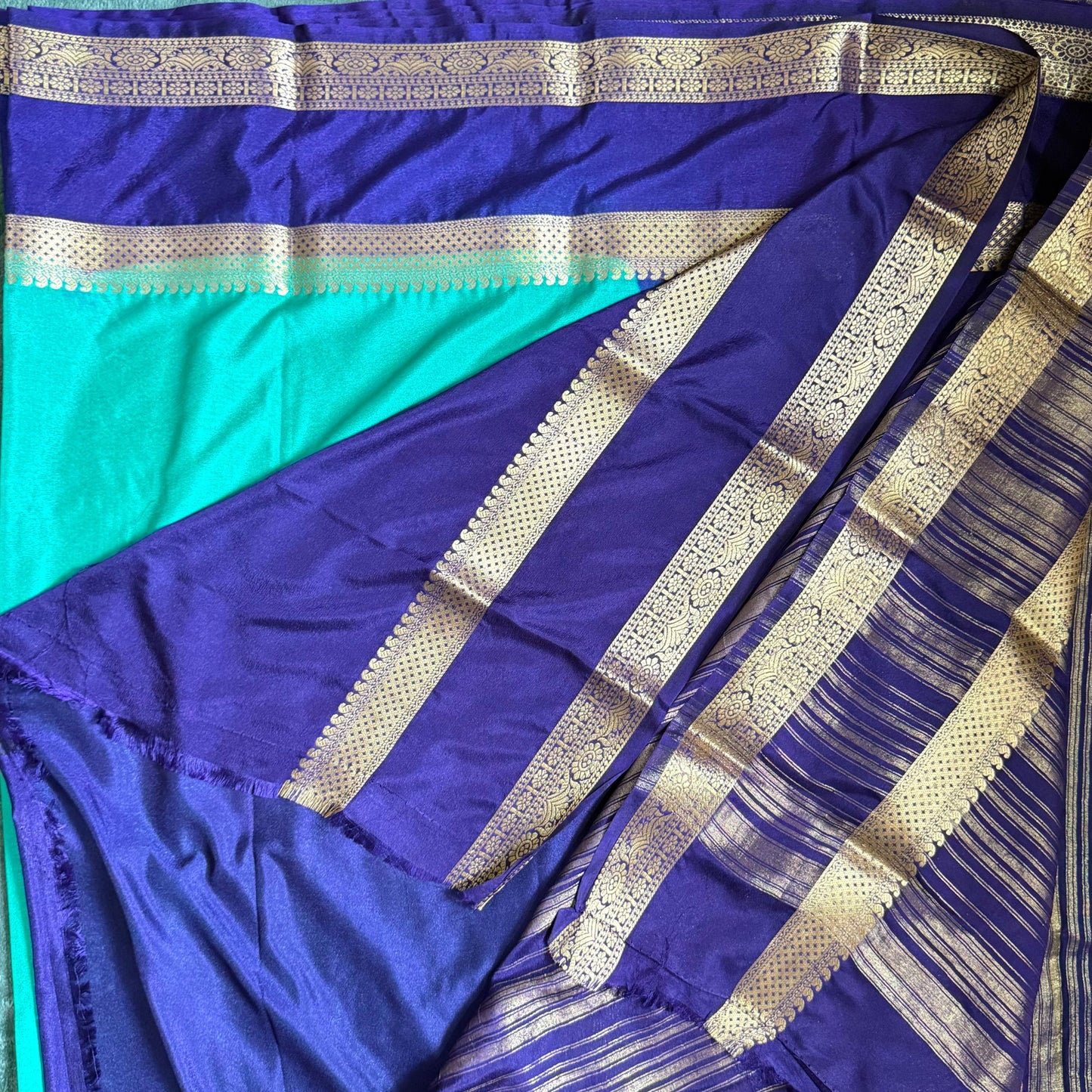 Purple saree with gold border on a wooden surface