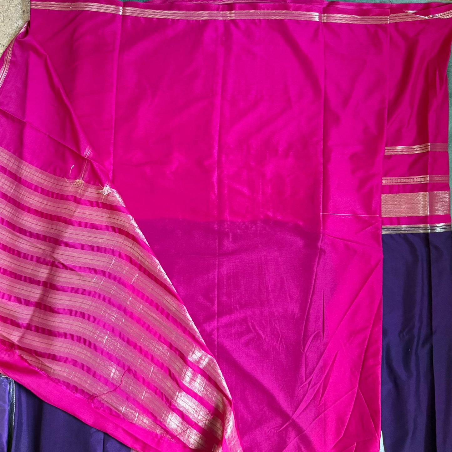 Pink and purple saree with a visible border on a flat surface