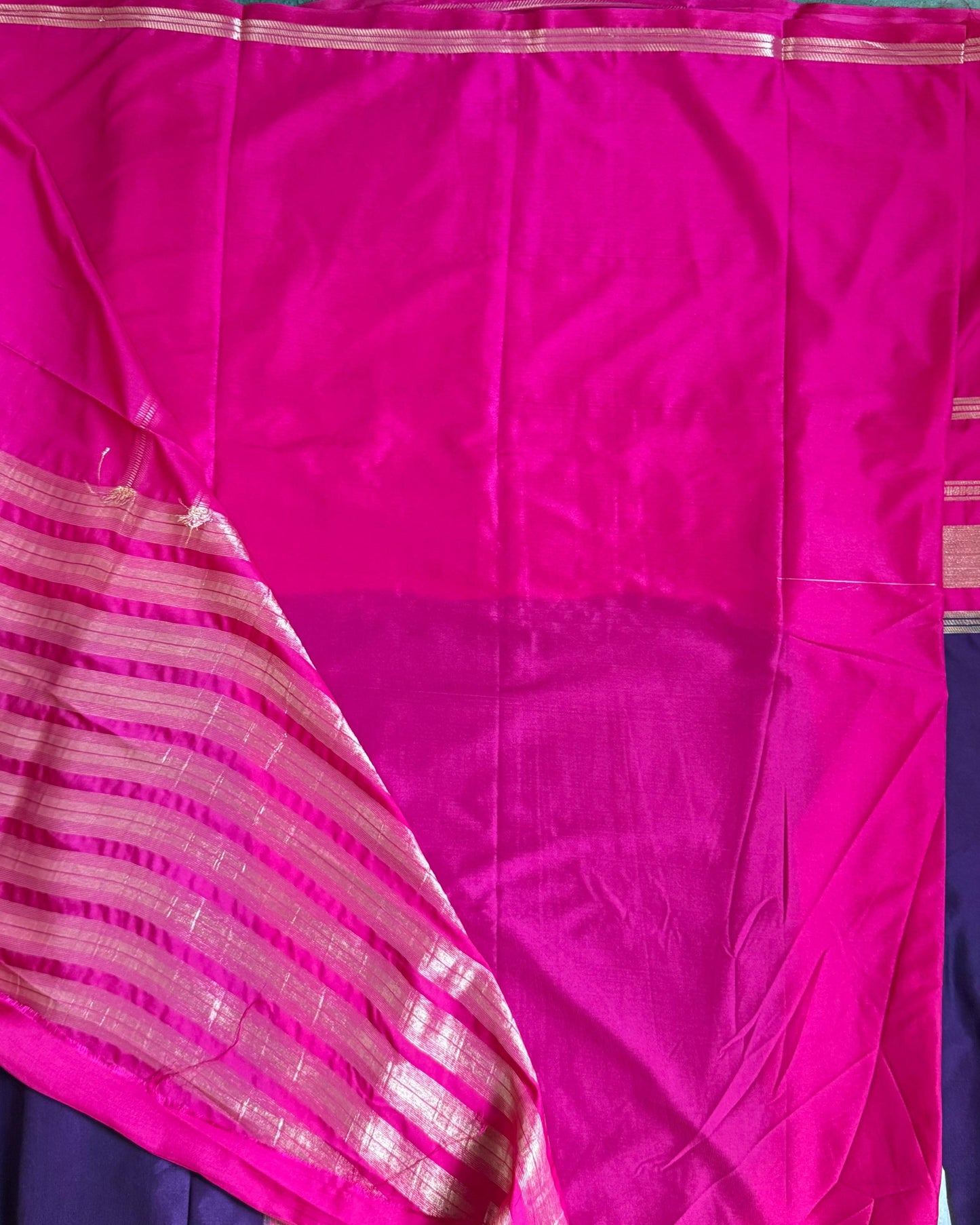 Pink and purple saree with a visible border on a flat surface