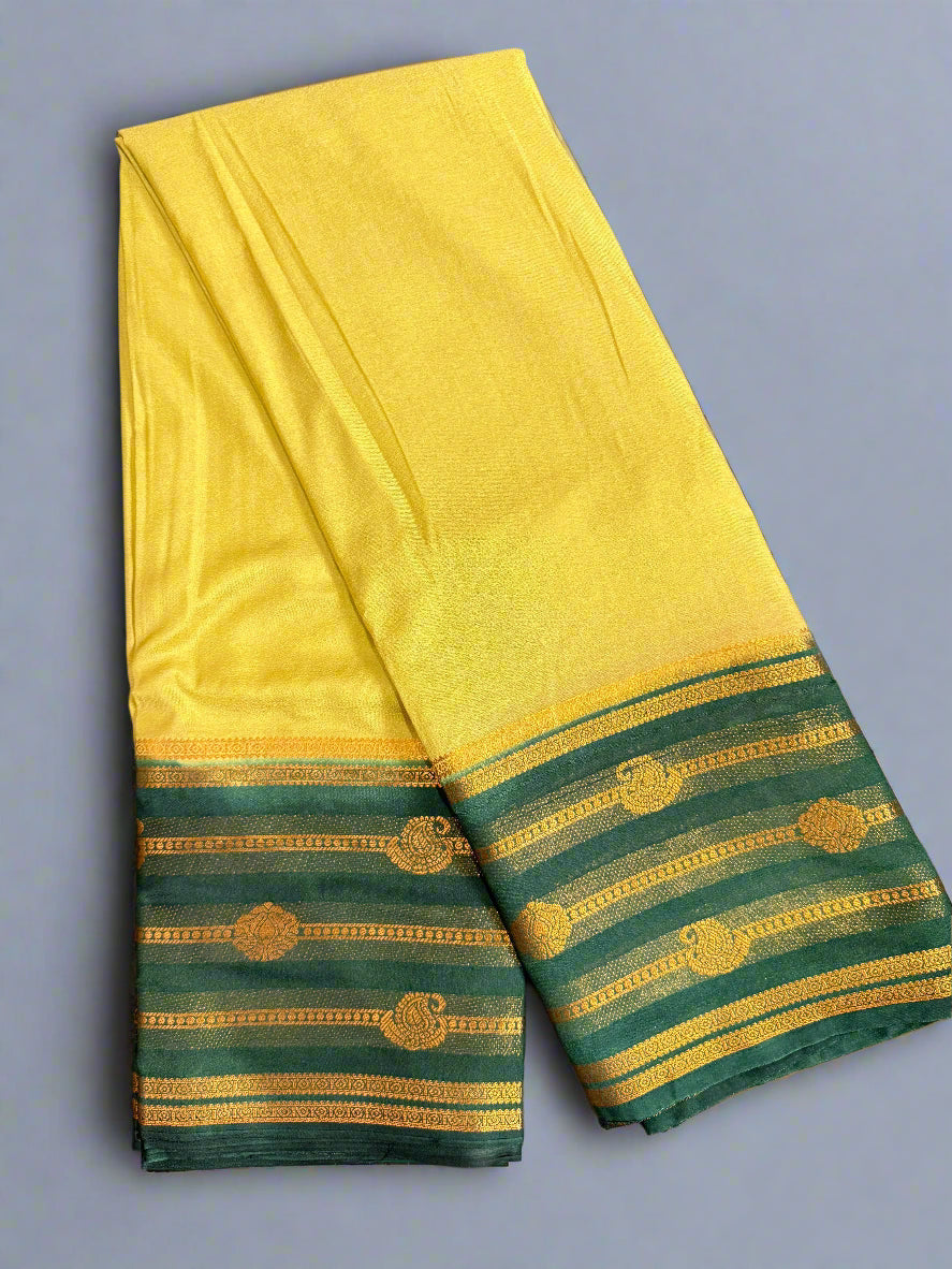 Yellow saree with green and gold border on a gray background