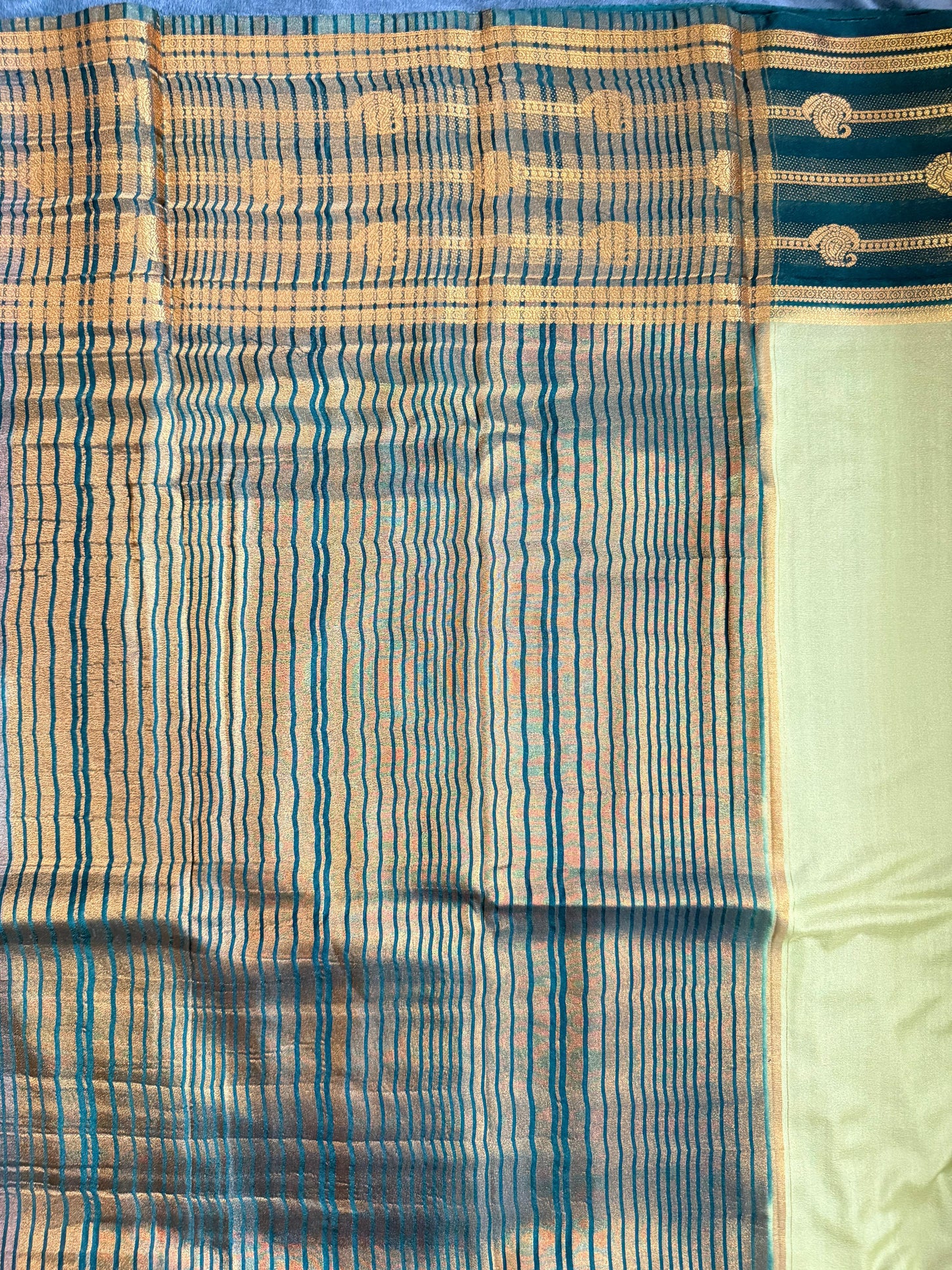 Sari with blue and gold pattern on a plain background