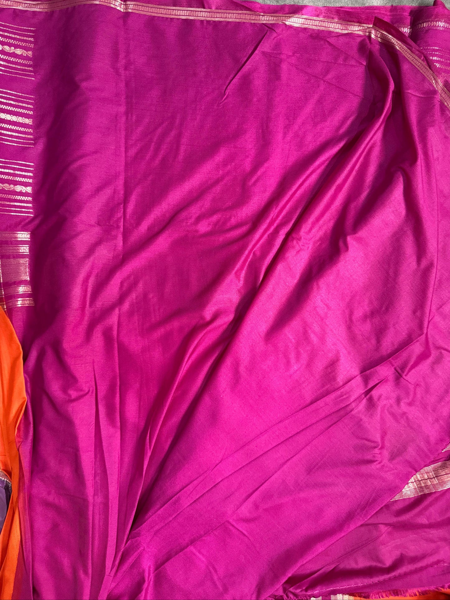 Purple fabric with a pink border on a gray background