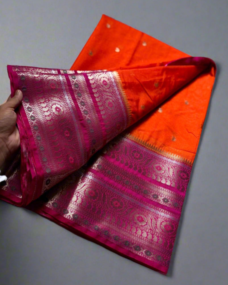 Two colorful sarees, one pink and one orange, on a marble surface.