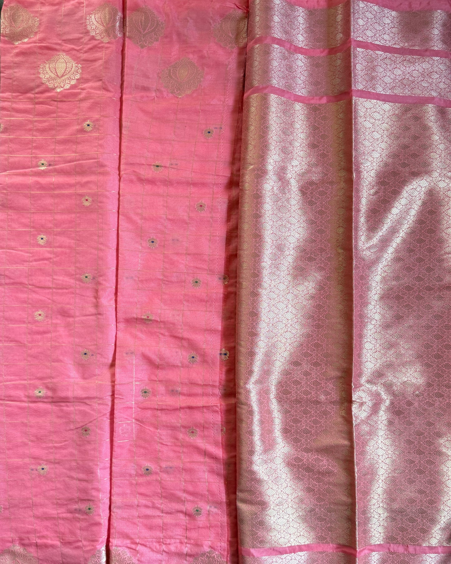 Pink fabric with gold patterns on a green surface