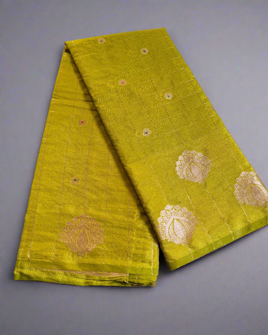 Green fabric with gold patterns on a gray surface