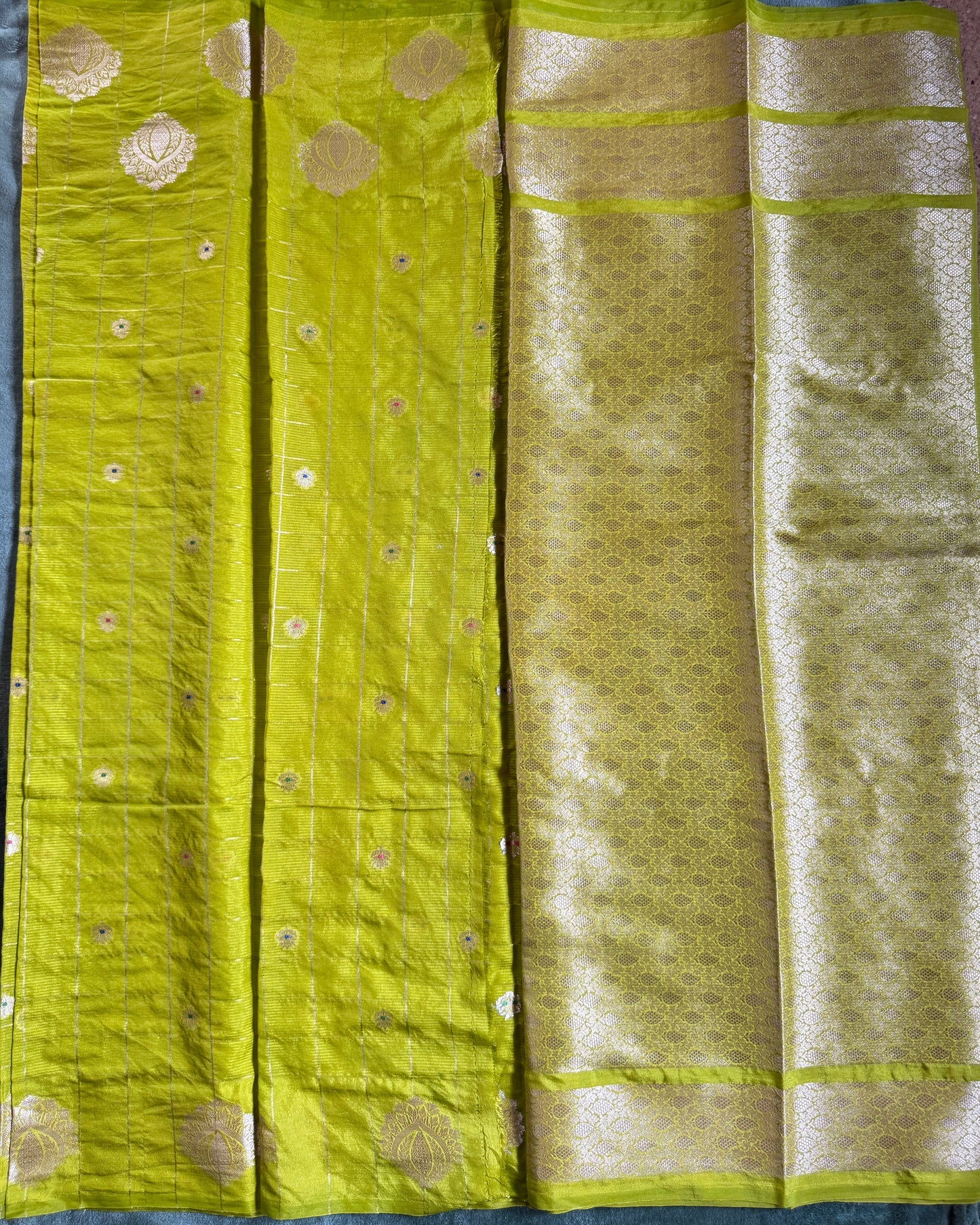 Green fabric with gold patterns on a dark background