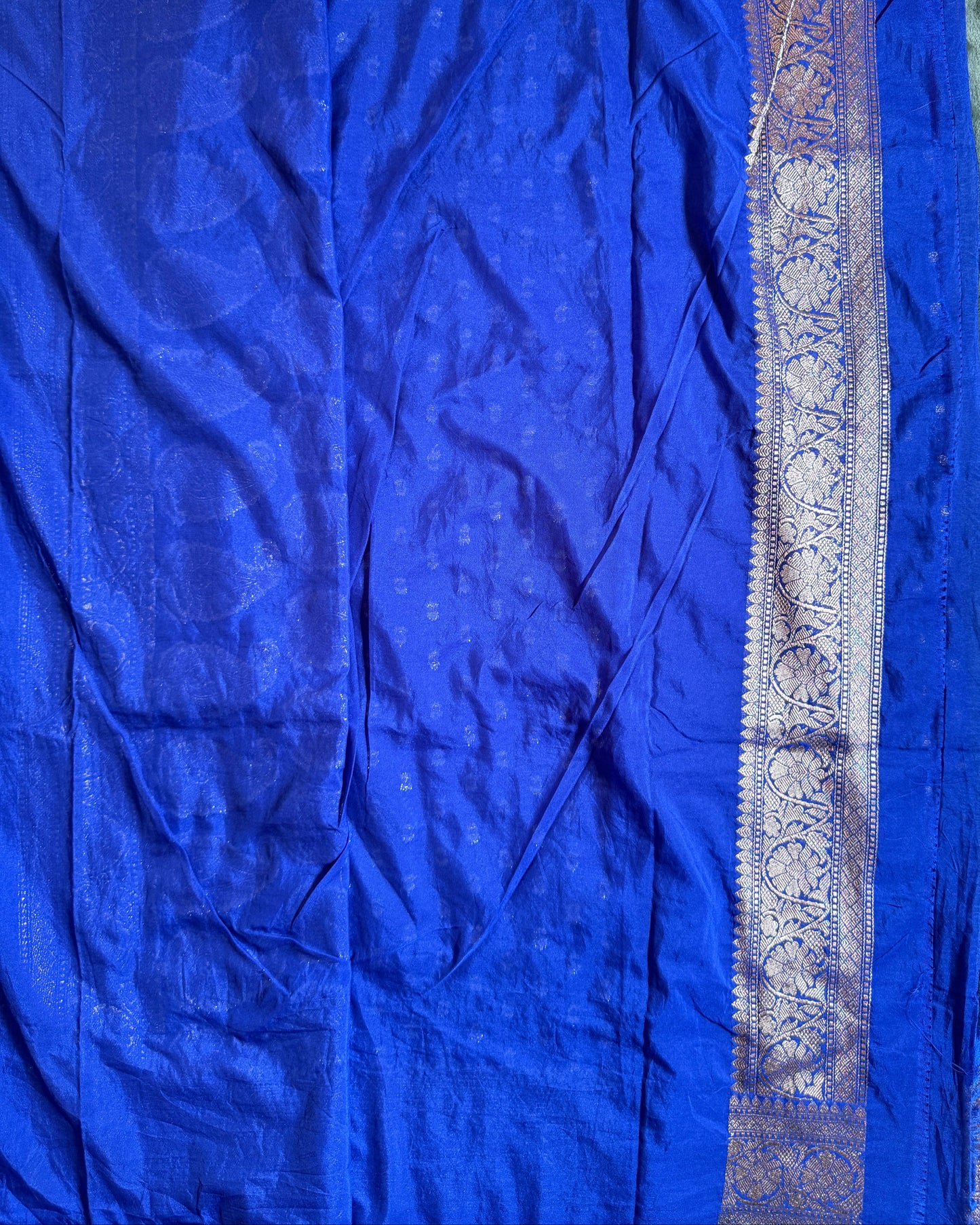 Blue fabric with a decorative border on a plain background