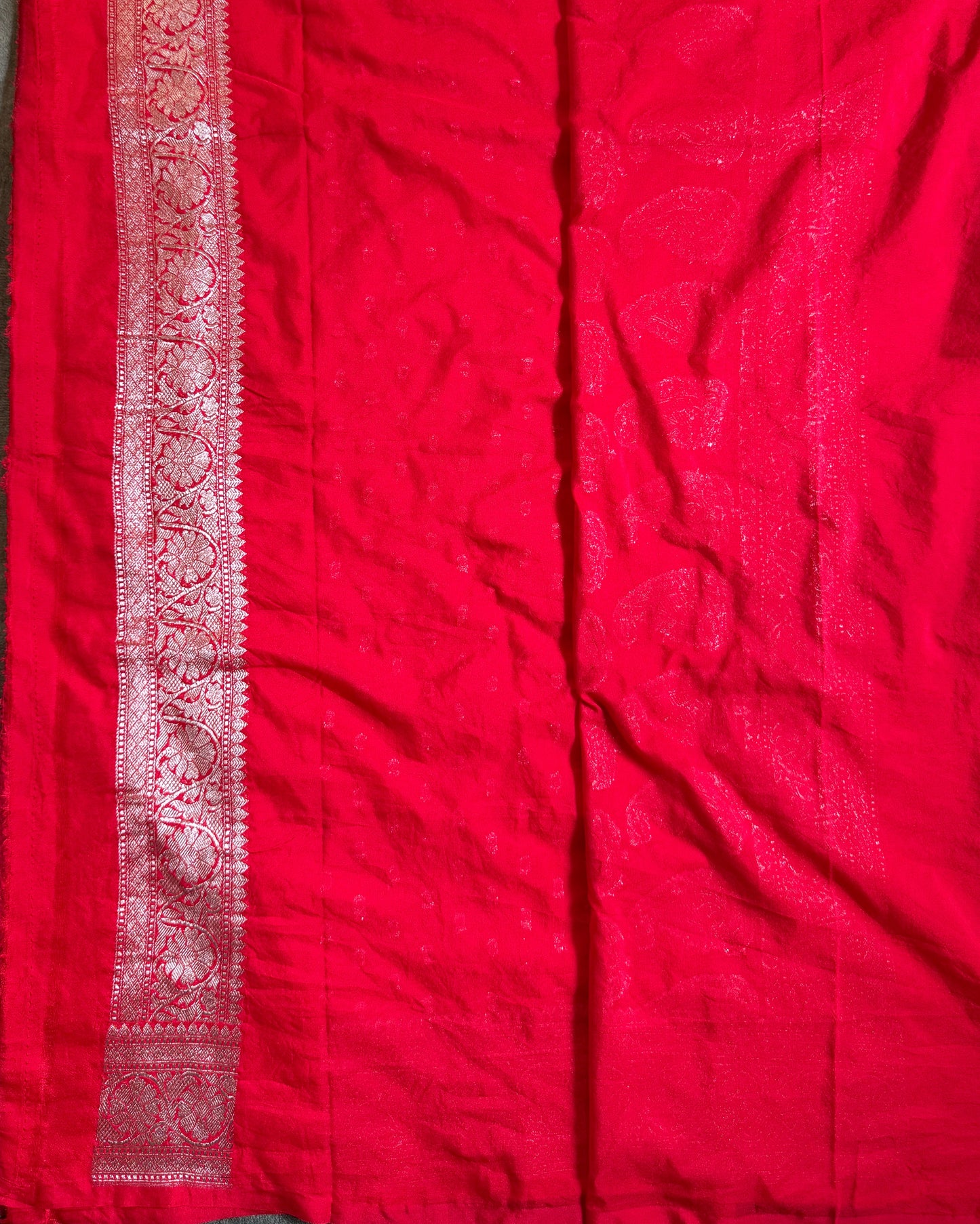 Red fabric with intricate patterns on a flat surface