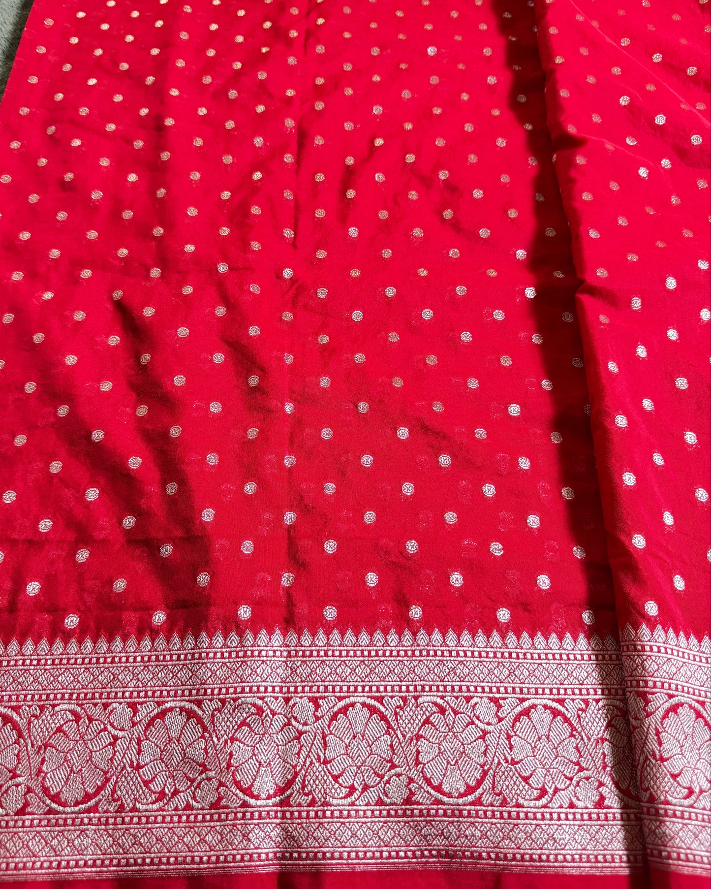 Red fabric with white polka dots and a decorative border