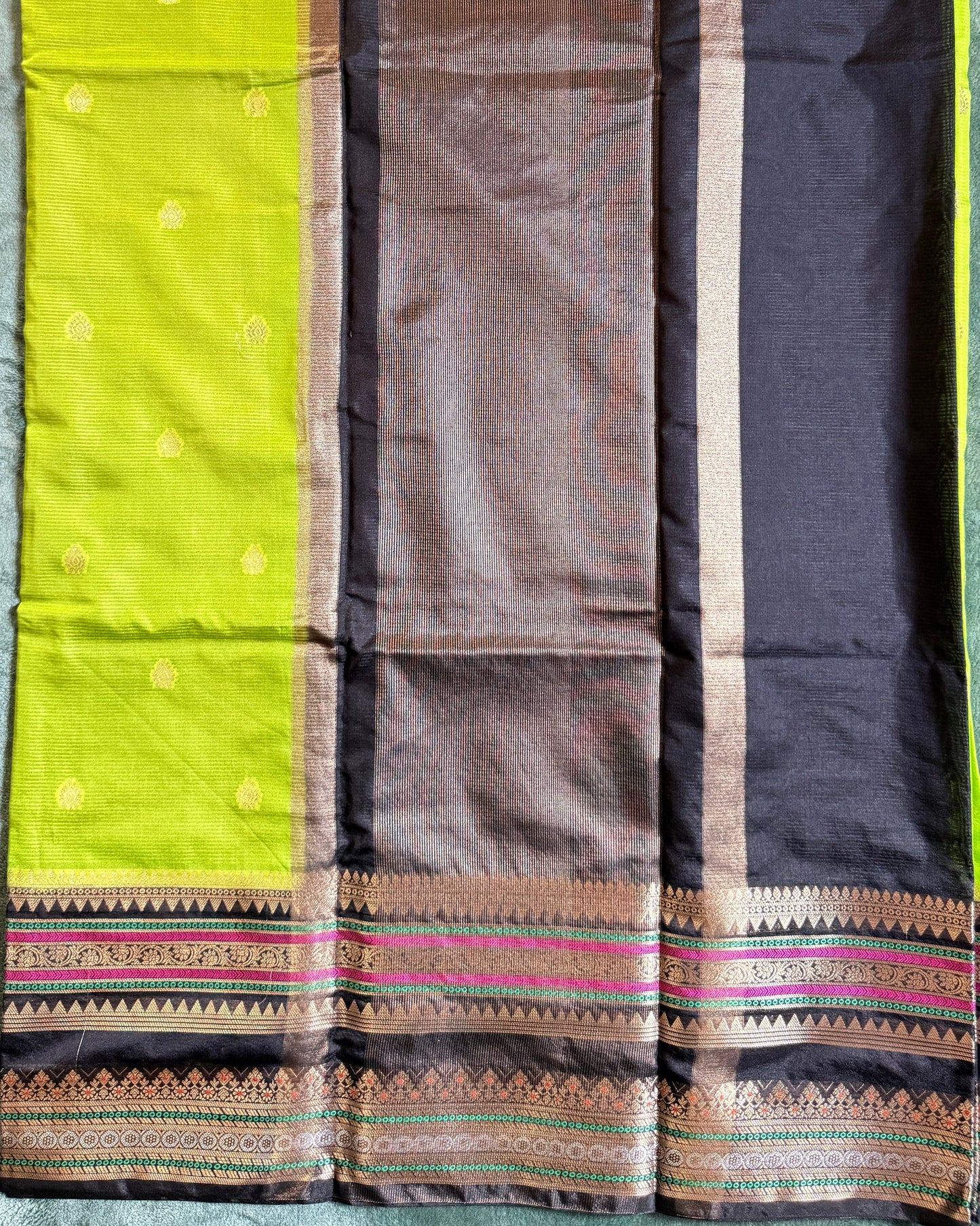 Saree with a black, brown, and green pattern on a light blue fabric background