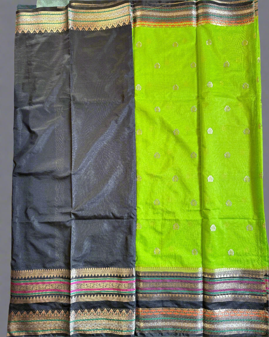 Green and black saree with decorative borders on a textured surface