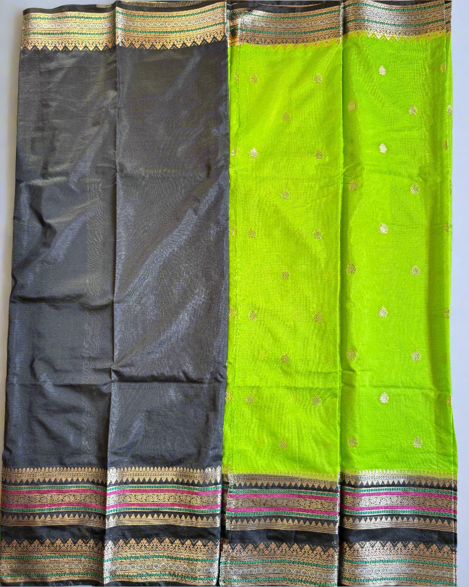 Green and black saree with decorative patterns on a flat surface
