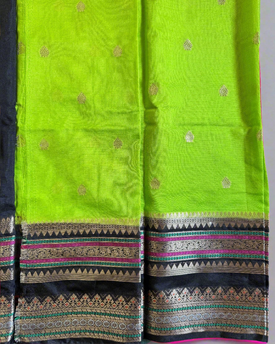 Green fabric with intricate patterns on a dark background