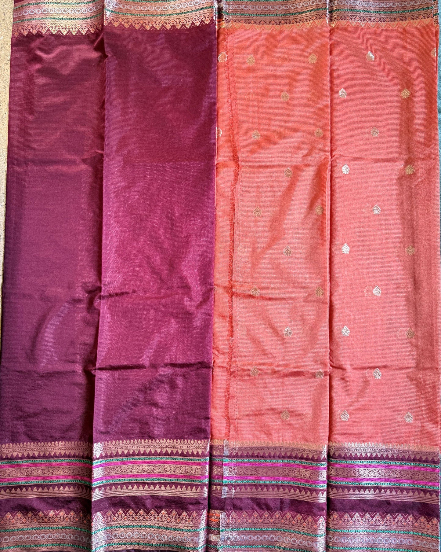 Two sarees, one pink and one maroon, with decorative borders on a blue background.