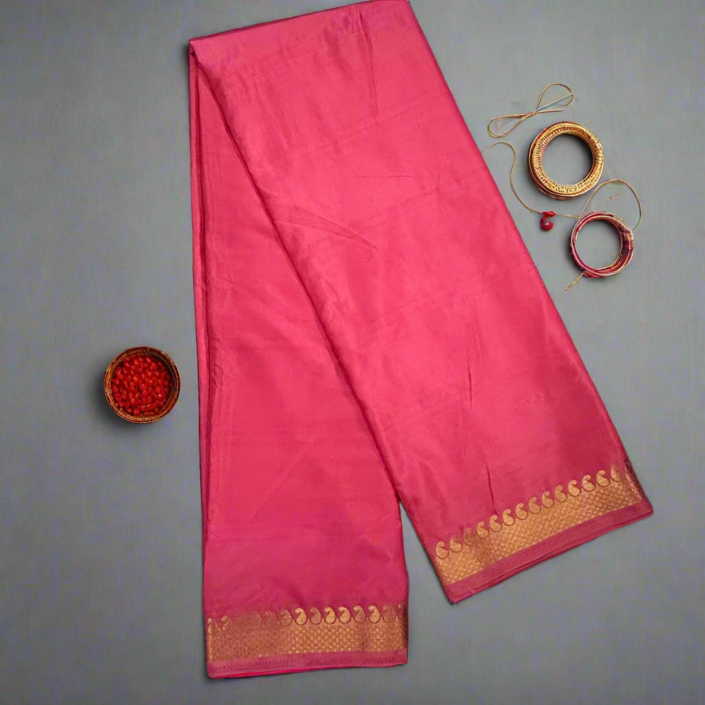 Pink saree with gold border on a dark textured background