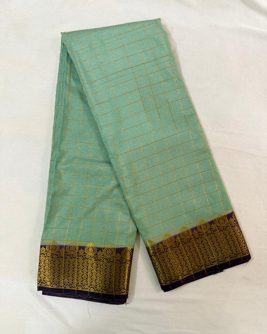 Light blue saree with gold and purple border on a white background