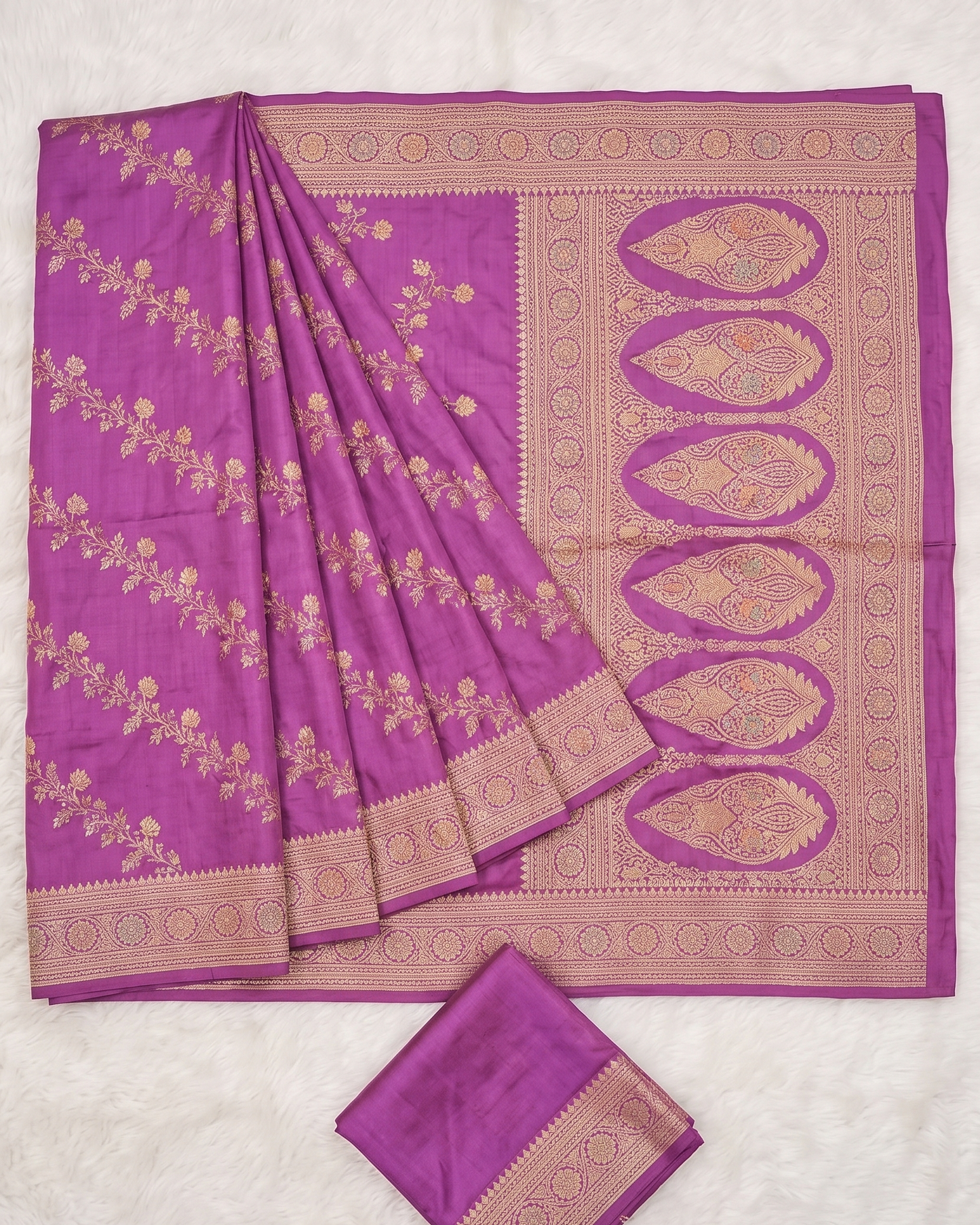 Purple saree with gold embroidery on a light gray background