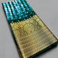 Traditional saree with green and gold pattern on a gray background