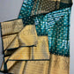 Traditional saree with green and gold patterns on a gray background