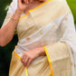 Woman in a traditional saree with green foliage in the background