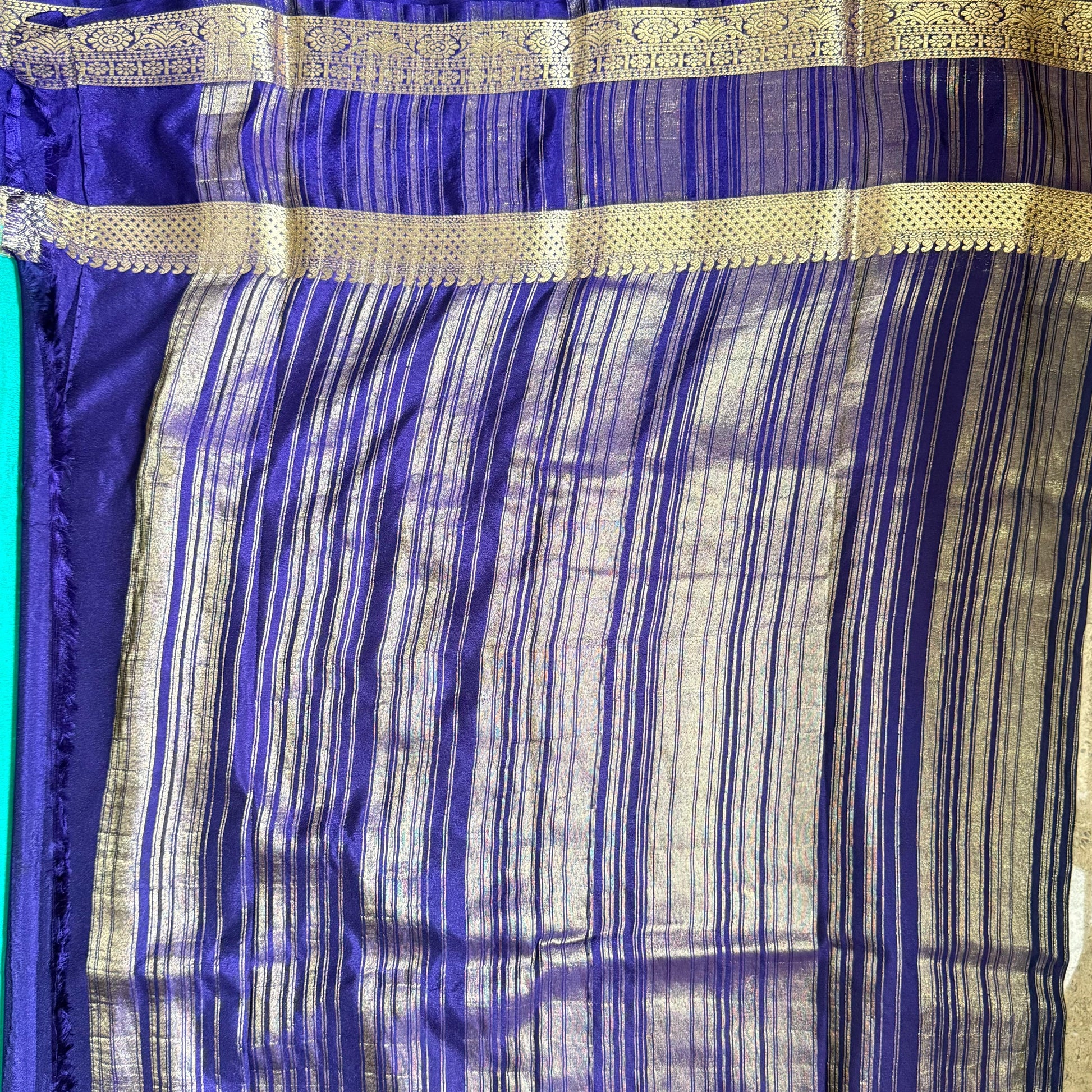 Blue and gold striped fabric on a plain background