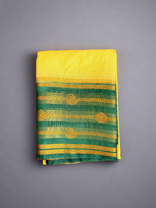 Yellow and green saree with gold patterns on a gray background