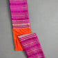 Folded fabric with pink and orange stripes on a textured gray background