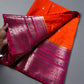 Two colorful sarees, one pink and one orange, on a marble surface.