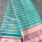 Striped fabric with pink and gold border on a grass background
