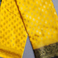 Yellow fabric with gold patterns on a gray background