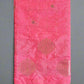 Pink fabric with embroidered patterns on a gray background