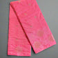 Pink fabric with floral patterns on a gray textured surface