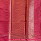 Pink fabric with intricate patterns and embroidery on a dark background