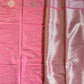 Pink fabric with gold patterns on a green surface