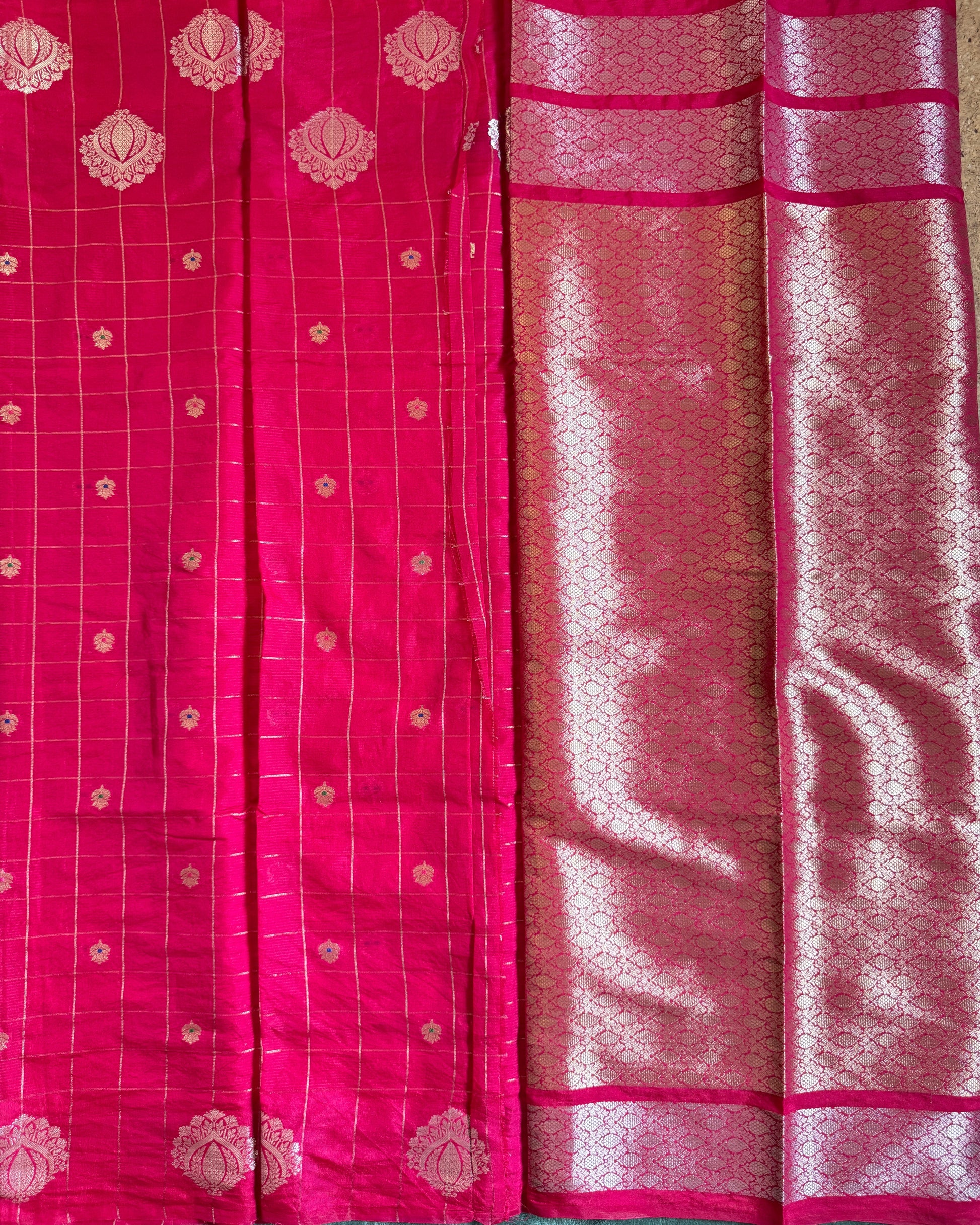 Red saree with gold patterns on a green background