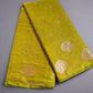 Green fabric with gold patterns on a gray surface
