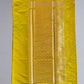 Yellow fabric roll on a gray surface with a black sandal partially visible.