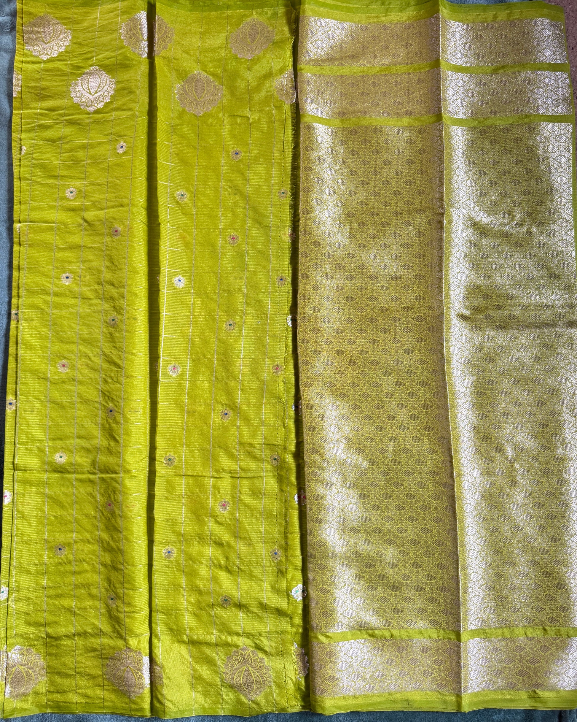 Green fabric with gold patterns on a dark background