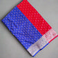 Red and blue fabric with a patterned border on a gray surface