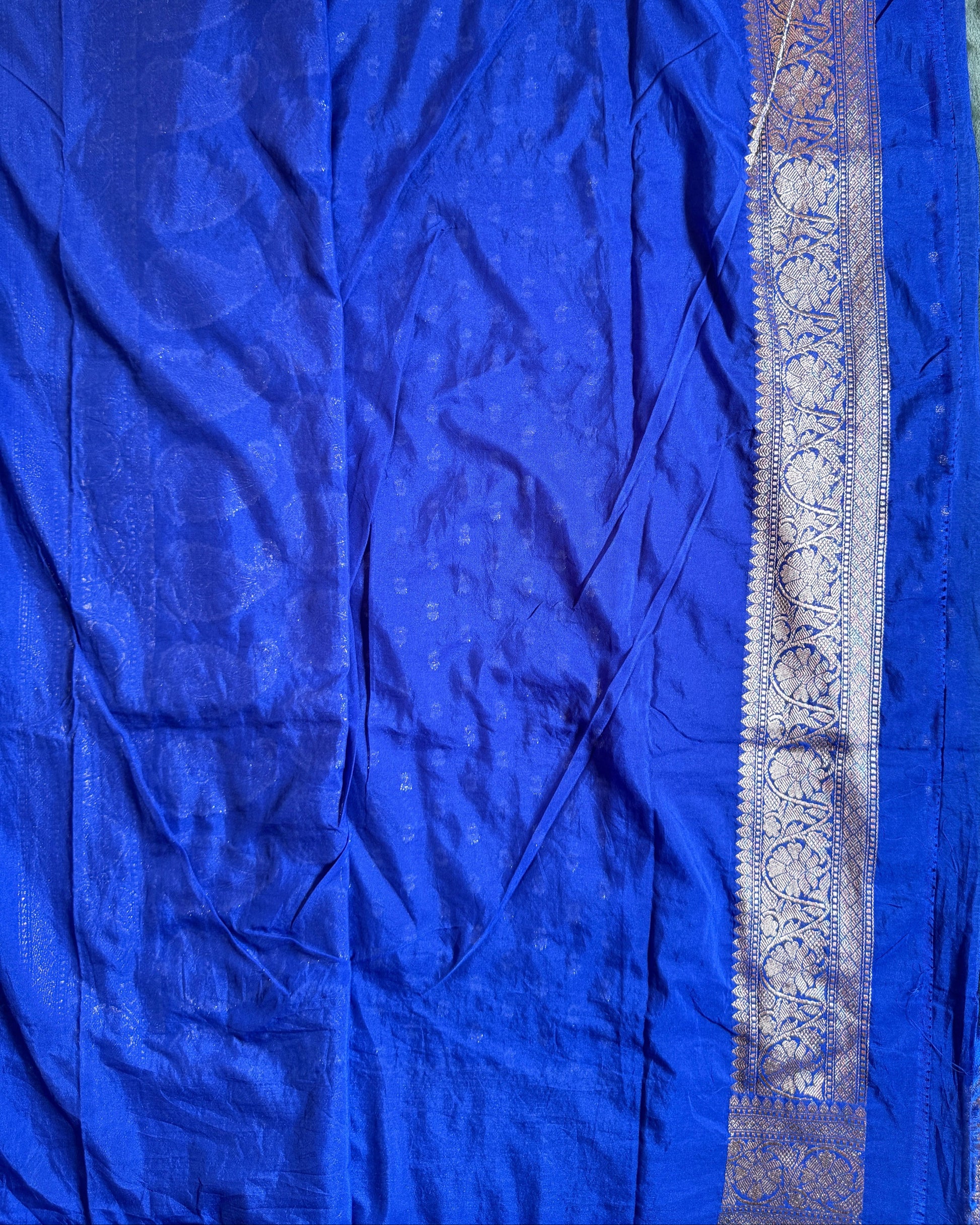Blue fabric with a decorative border on a plain background