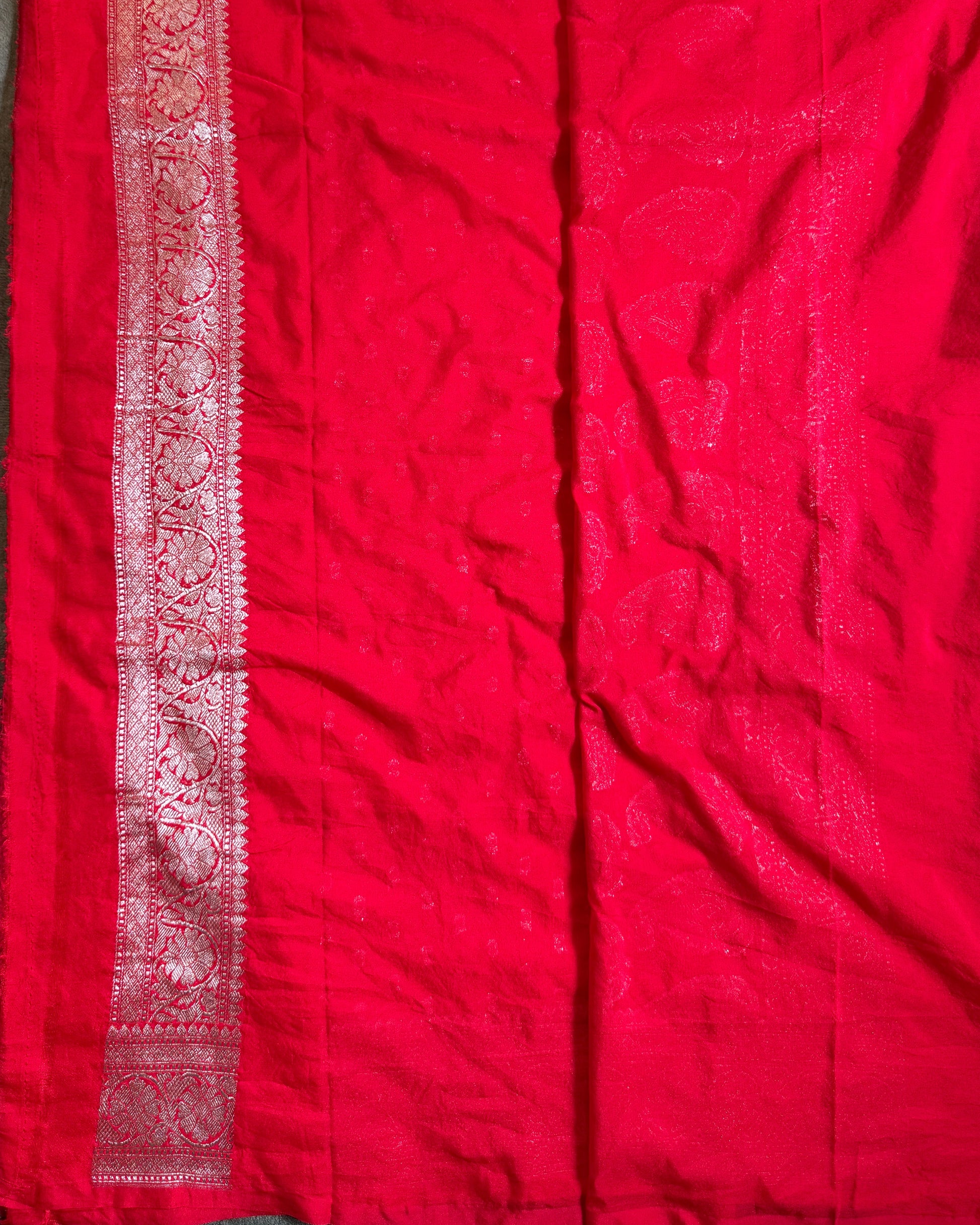 Red fabric with intricate patterns on a flat surface