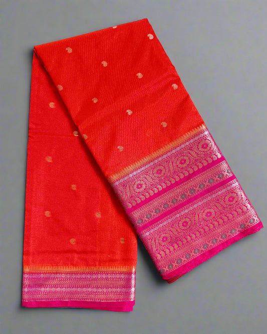 Red saree with pink border on a textured gray background