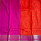 Red and pink saree with a pattern on a green surface