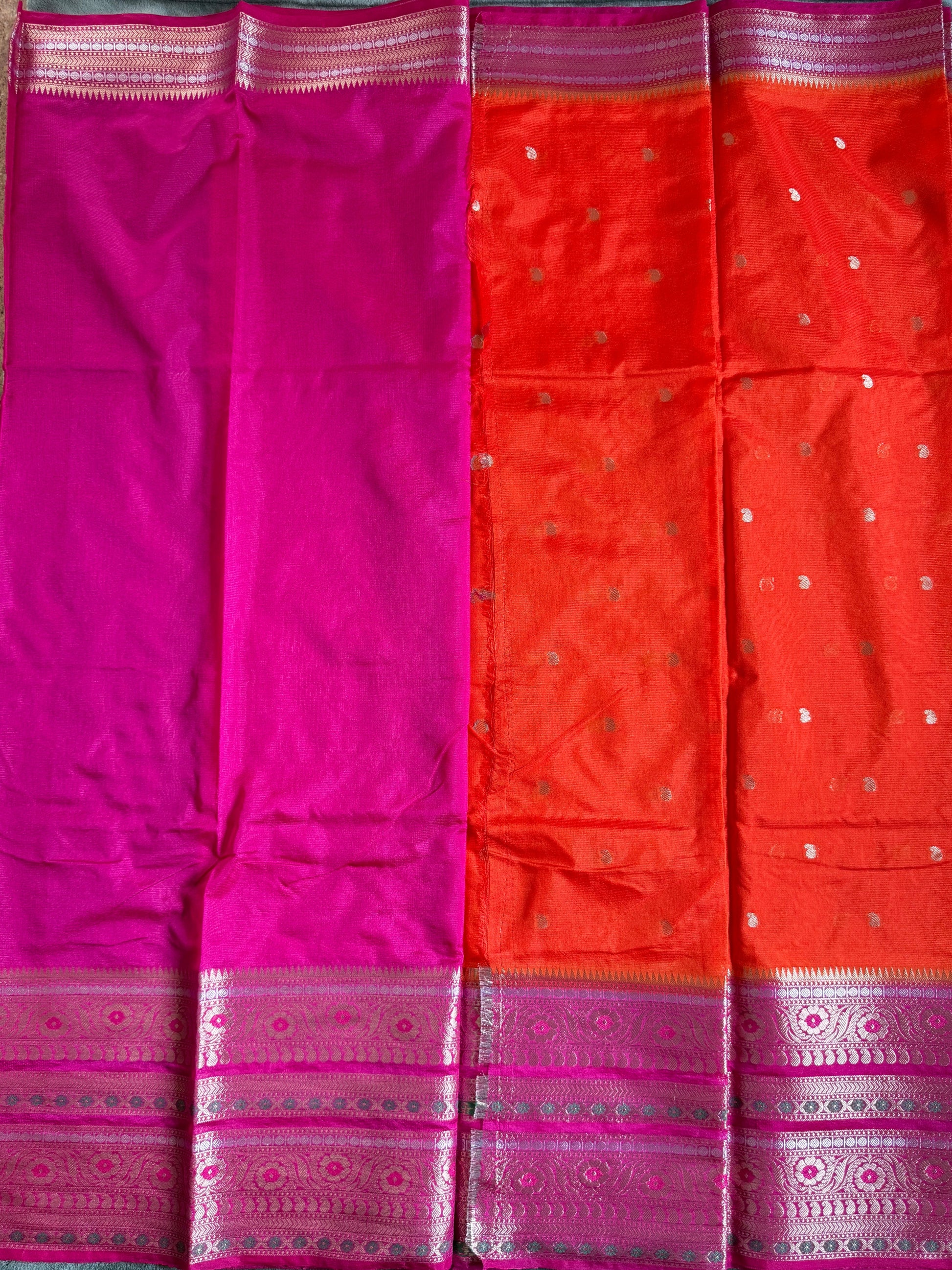 Red and pink saree with a pattern on a green surface