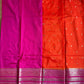 Saree with orange and pink fabric and decorative border on a gray background