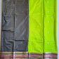 Green and black saree with decorative patterns on a flat surface