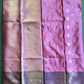 Pink and purple saree with intricate patterns on a green surface