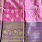 Pink and purple saree with intricate patterns on a green background
